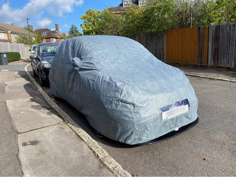 A car cover with a cut-out for the number plate area, leaving the number plate visible, installed on a car.