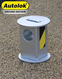 Autolok telescopic motorcycle security ground anchor with a silver finish and yellow warning sticker, set in a concrete surface.